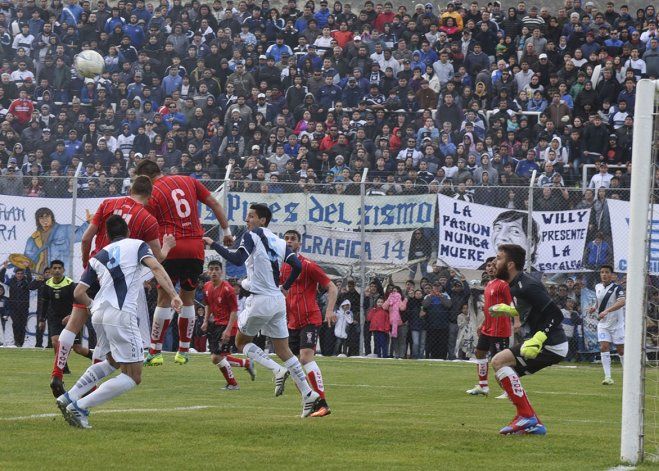 Una postal del clásico. La defensa despeja ante un marco de público imponente.